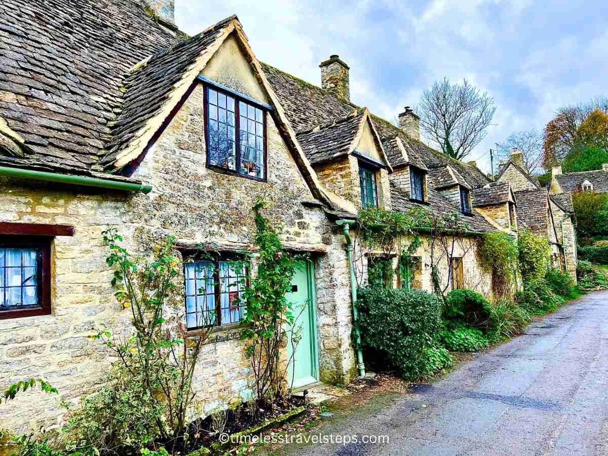 view of pretty cottages along Arlington Row, with eau de nil doors Bibury Cotswolds