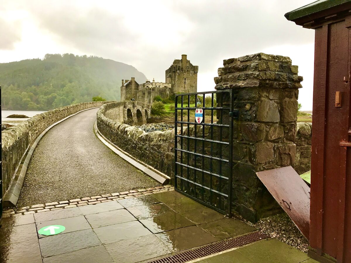 view of the entrance to Eilean Donan Castle across the stone bridge from the main gates