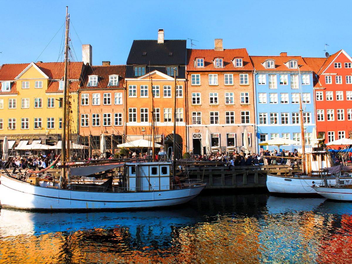 view of colourful buildings along a canal and boats in Copenhagen