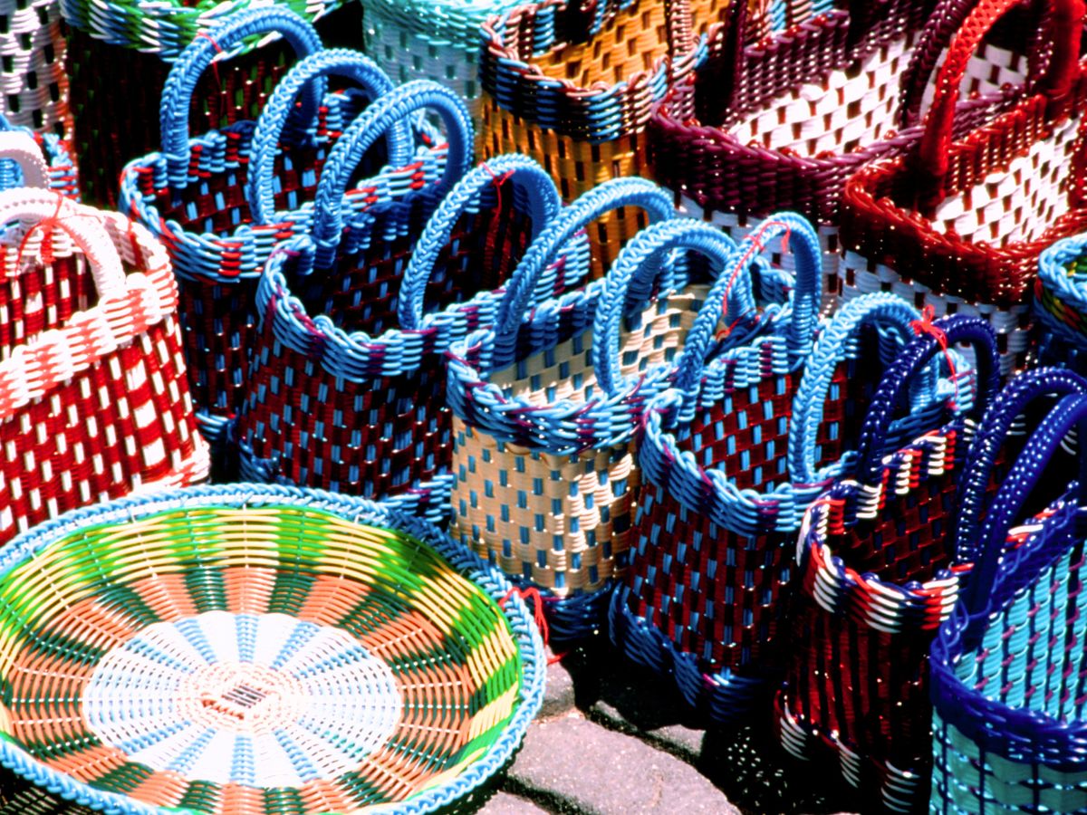 Stacks of colourful handmade woven baskets on display at a vibrant market in Oaxaca, showcasing traditional craftsmanship and cultural heritage. | Guide to Sustainable Travel for Heritage and Culture Explorers + Tips