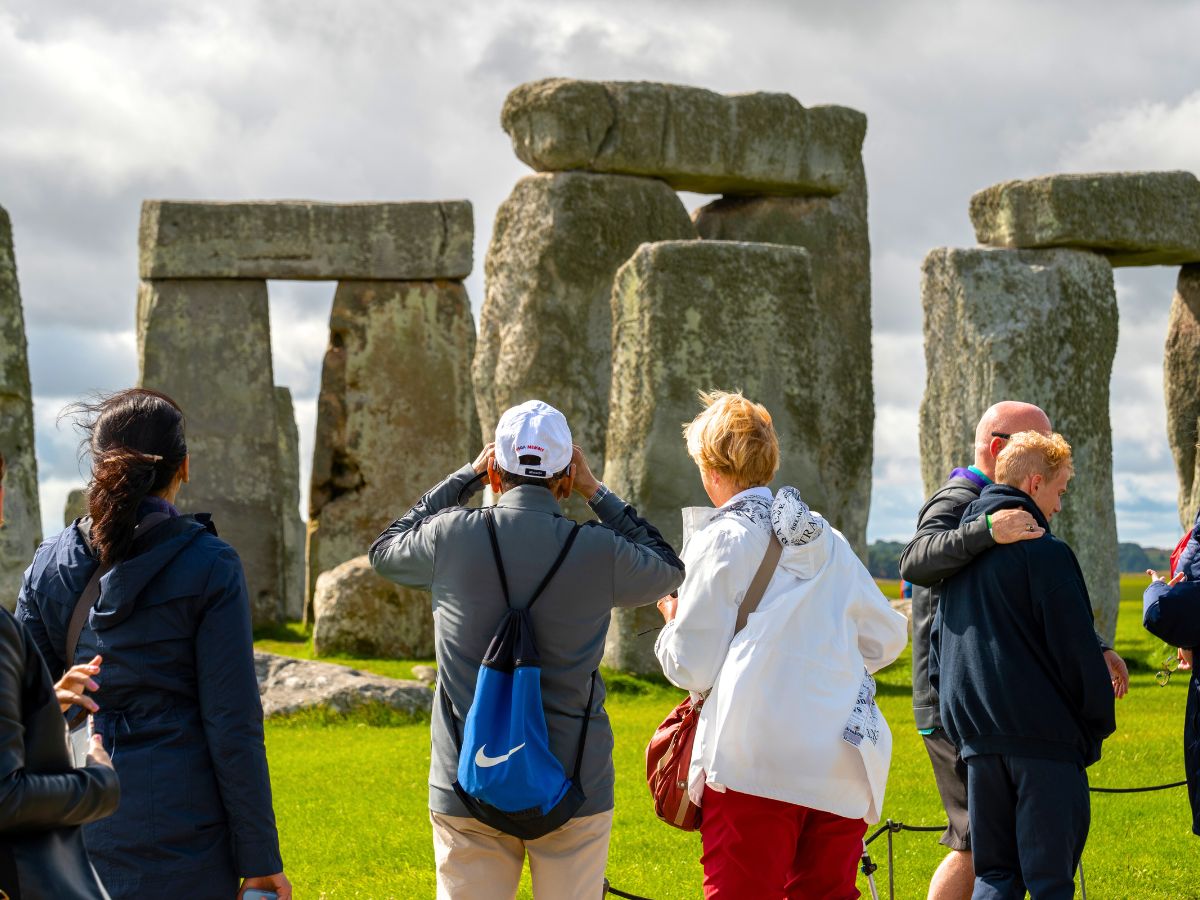 a group of people visiting Stonehenge in the UK | Guide to Sustainable Travel for Heritage and Culture Explorers + Tips