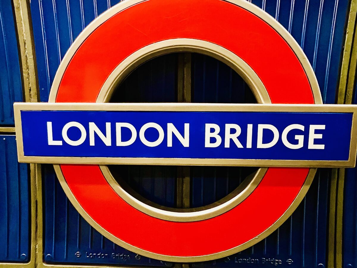 A sign that says London bridge - the iconic red circle and a line across of the London Underground