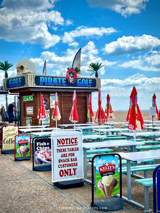 Pirate Golf attraction and seating area on Brighton seafront during a day trip to Brighton.